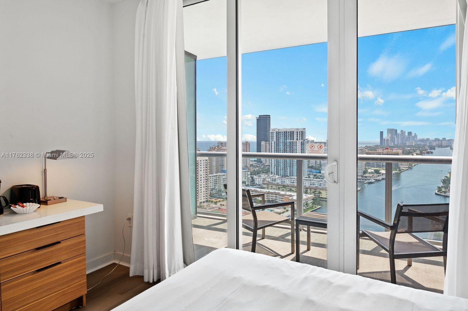 2602 East Hallandale Beach Boulevard, Unit R2703 Hallandale Beach, FL 33009 - Photo 33 of 50 a bedroom with a bed and a window