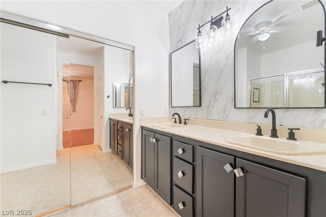 5389 Progresso Street Las Vegas, NV 89135 - Photo 19 of 41 Dual vanities with sleek black fixtures and substantial storage elevate this primary bathroom's appeal.