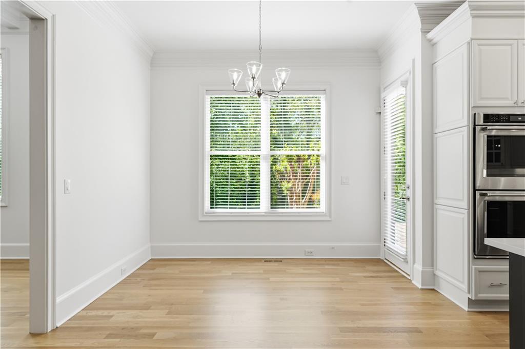 6740 Castleton Drive Northwest Sandy Springs, GA 30328 - Photo 15 of 58 a view of an empty room with window and wooden floor