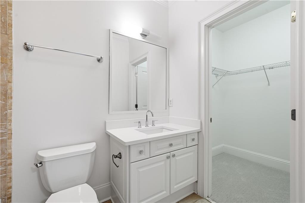 6740 Castleton Drive Northwest Sandy Springs, GA 30328 - Photo 23 of 58 a bathroom with a toilet sink vanity and mirror
