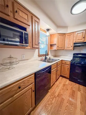 a kitchen with a sink stove top oven and cabinets