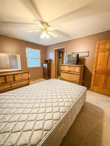 a bedroom with a bed and dresser with mirror