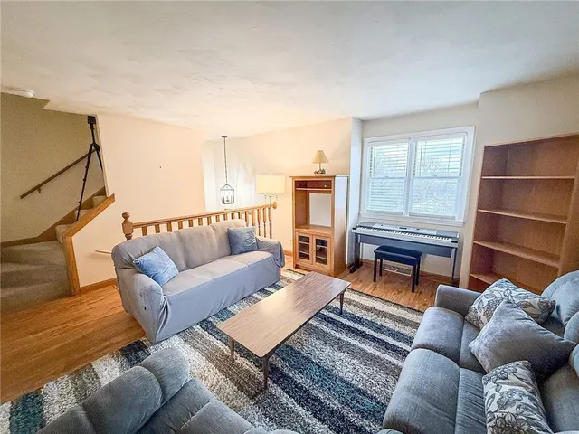 a living room with furniture a rug and a window