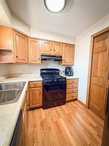 a kitchen with granite countertop wooden cabinets and a sink