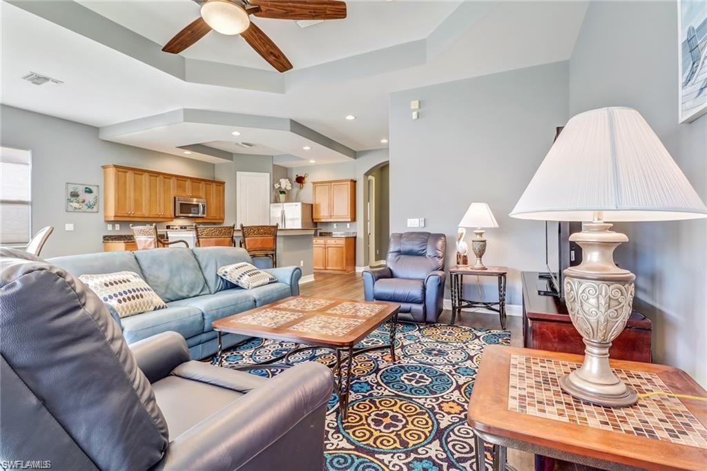 1374 Serrano Circle Naples, FL 34105 - Photo 12 of 37 a living room with furniture a rug and wall painting