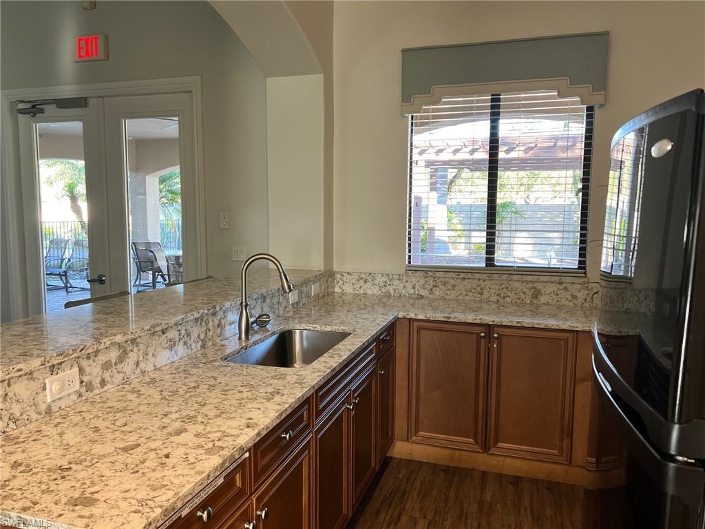 1374 Serrano Circle Naples, FL 34105 - Photo 31 of 37 a kitchen with granite countertop sink stove and cabinets