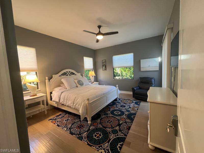 1374 Serrano Circle Naples, FL 34105 - Photo 37 of 37 a bedroom with a bed and a dresser with mirror