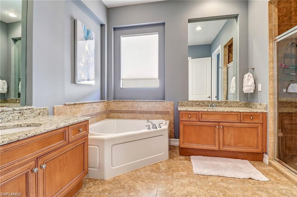 1374 Serrano Circle Naples, FL 34105 - Photo 4 of 37 a spacious bathroom with a granite countertop sink and a mirror