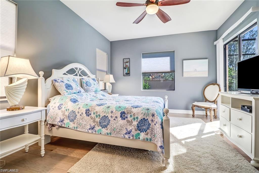 1374 Serrano Circle Naples, FL 34105 - Photo 5 of 37 a bedroom with a bed a chandelier with dresser and mirror