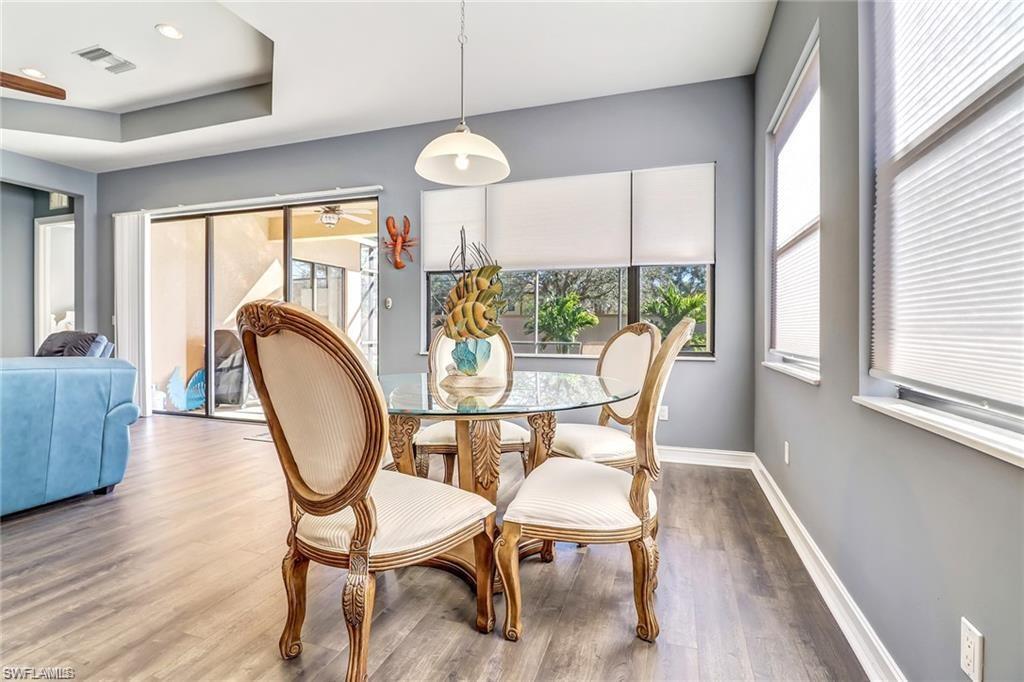 1374 Serrano Circle Naples, FL 34105 - Photo 7 of 37 a dining room with furniture a chandelier and wooden floor