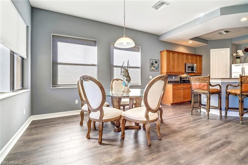 1374 Serrano Circle Naples, FL 34105 - Photo 8 of 37 a dining room with furniture a chandelier and wooden floor
