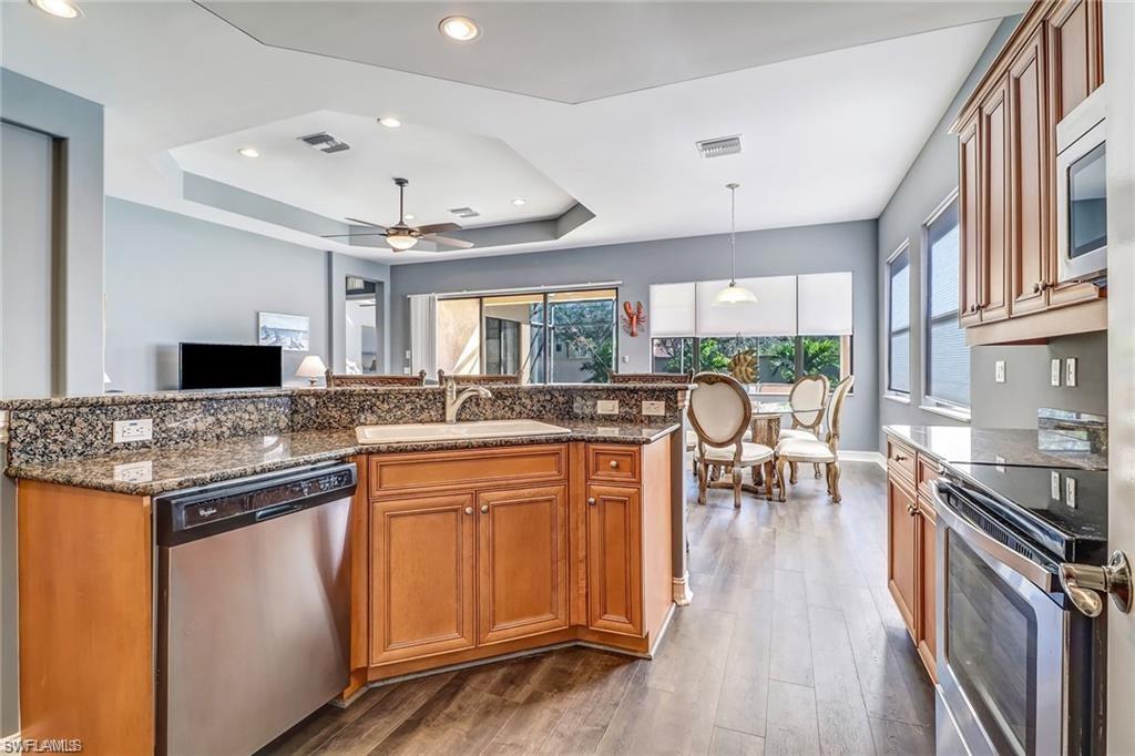 1374 Serrano Circle Naples, FL 34105 - Photo 9 of 37 a kitchen with stainless steel appliances granite countertop a stove and a view of living room