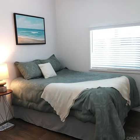 a bedroom with a bed and a painting on the wall
