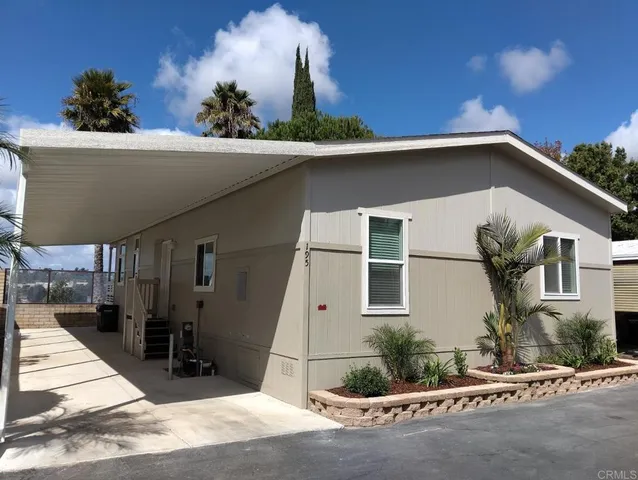 a view of a white house with large windows and plants