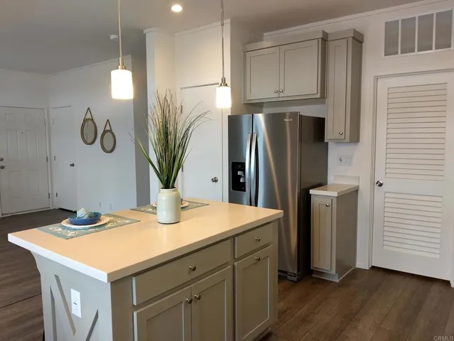 a kitchen with stainless steel appliances kitchen island a refrigerator sink and cabinets