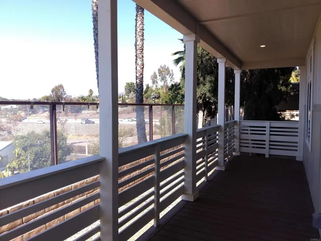 a view of a balcony with floor to ceiling windows and wooden floor