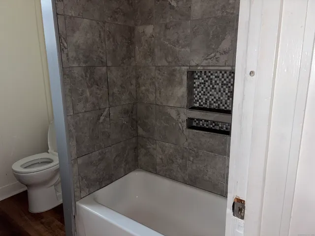 a bathroom with a bathtub and a toilet
