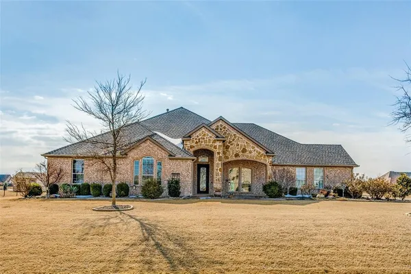a front view of a house with a yard and lake view