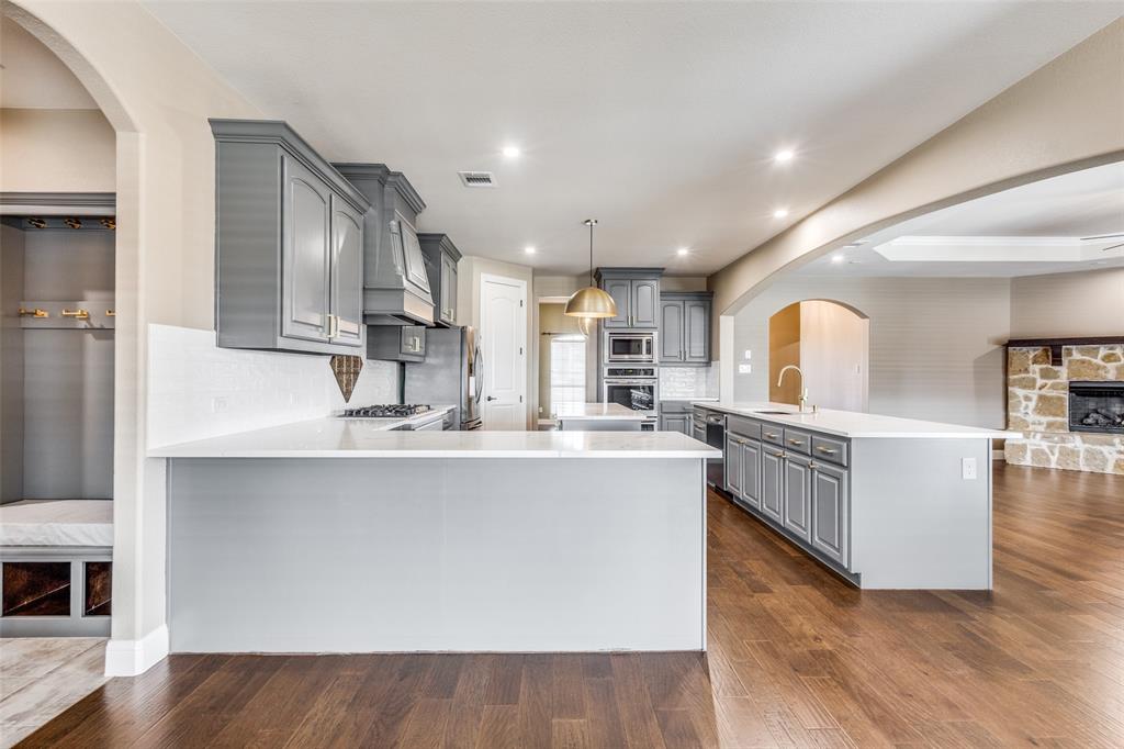 2143 Canyon Road Celina, TX 75009 - Photo 15 of 39 a large kitchen with stainless steel appliances a large counter top a stove and a sink