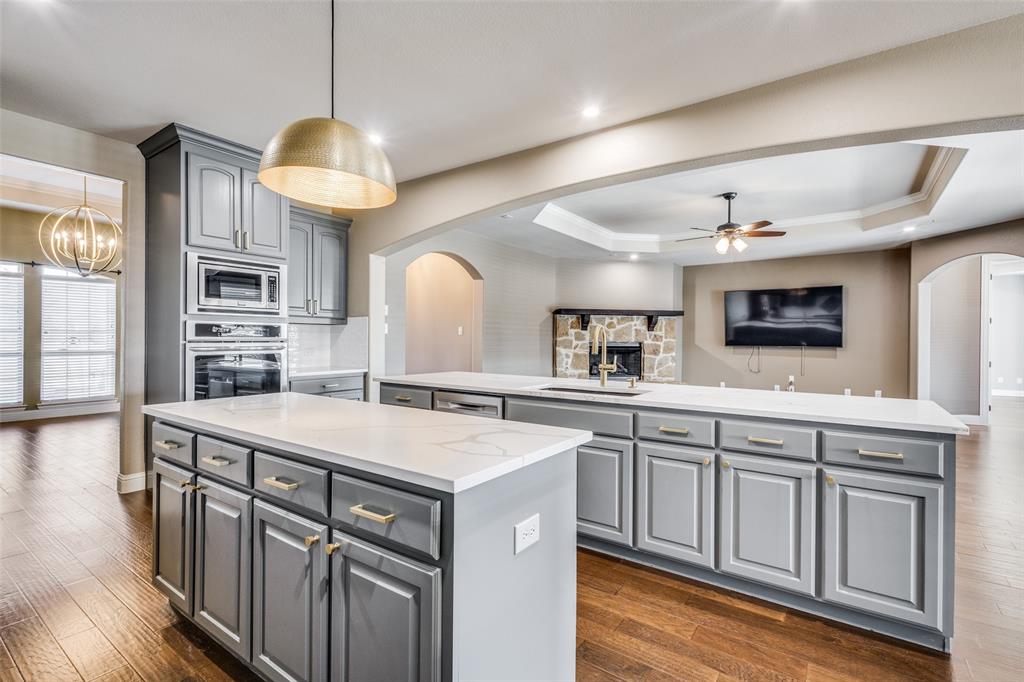 2143 Canyon Road Celina, TX 75009 - Photo 17 of 39 a kitchen that has a lot of cabinets in it and wooden floors