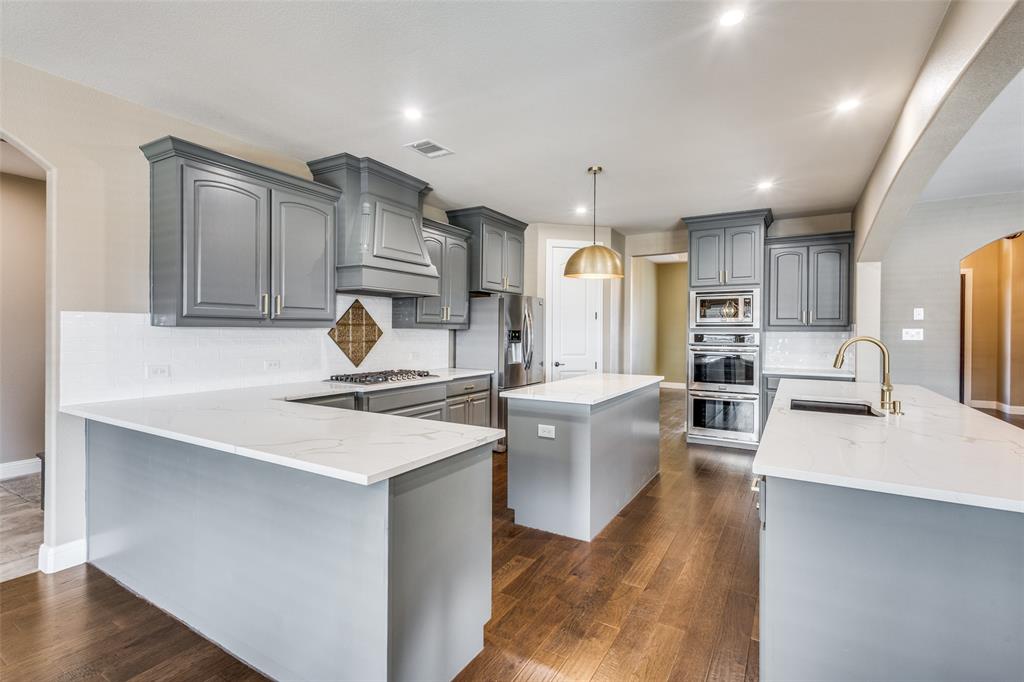 2143 Canyon Road Celina, TX 75009 - Photo 18 of 39 a kitchen with stainless steel appliances granite countertop a sink stove and refrigerator