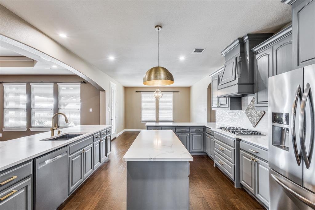 2143 Canyon Road Celina, TX 75009 - Photo 19 of 39 a kitchen with stainless steel appliances granite countertop a sink stove and refrigerator
