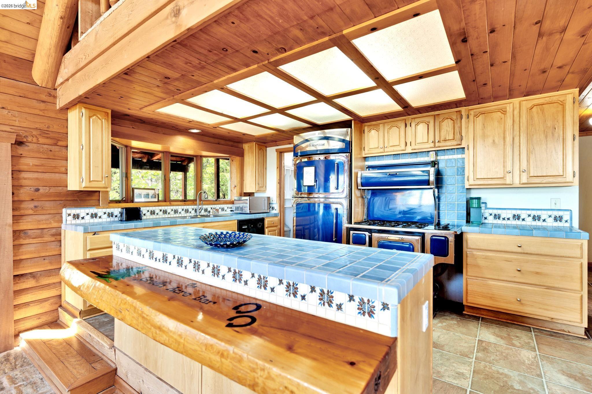 14799 Big Hill Road Sonora, CA 95370 - Photo 17 of 60 Kitchen with tile countertops, light wood finish cabinets, wood ceiling, and a kitchen island