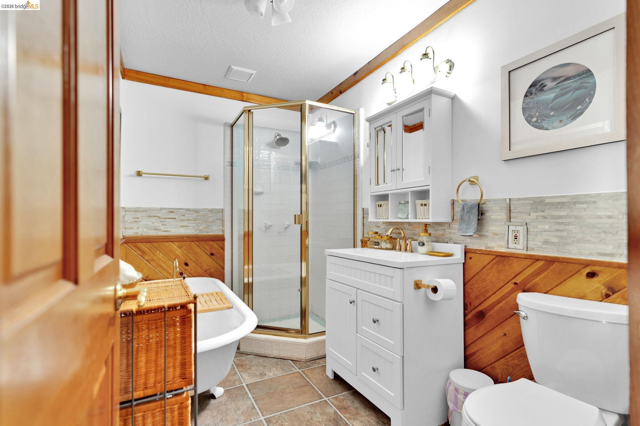 14799 Big Hill Road Sonora, CA 95370 - Photo 19 of 60 Full bathroom with a wainscoted wall, vanity, a shower stall, a freestanding tub, and a textured ceiling