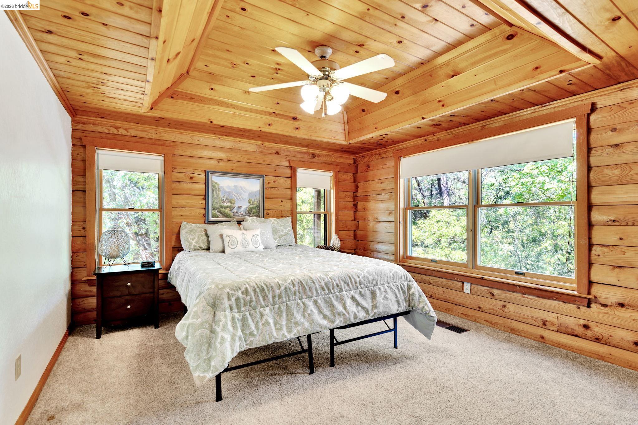 14799 Big Hill Road Sonora, CA 95370 - Photo 20 of 60 Bedroom with wooden ceiling, carpet flooring, a ceiling fan, and wood walls