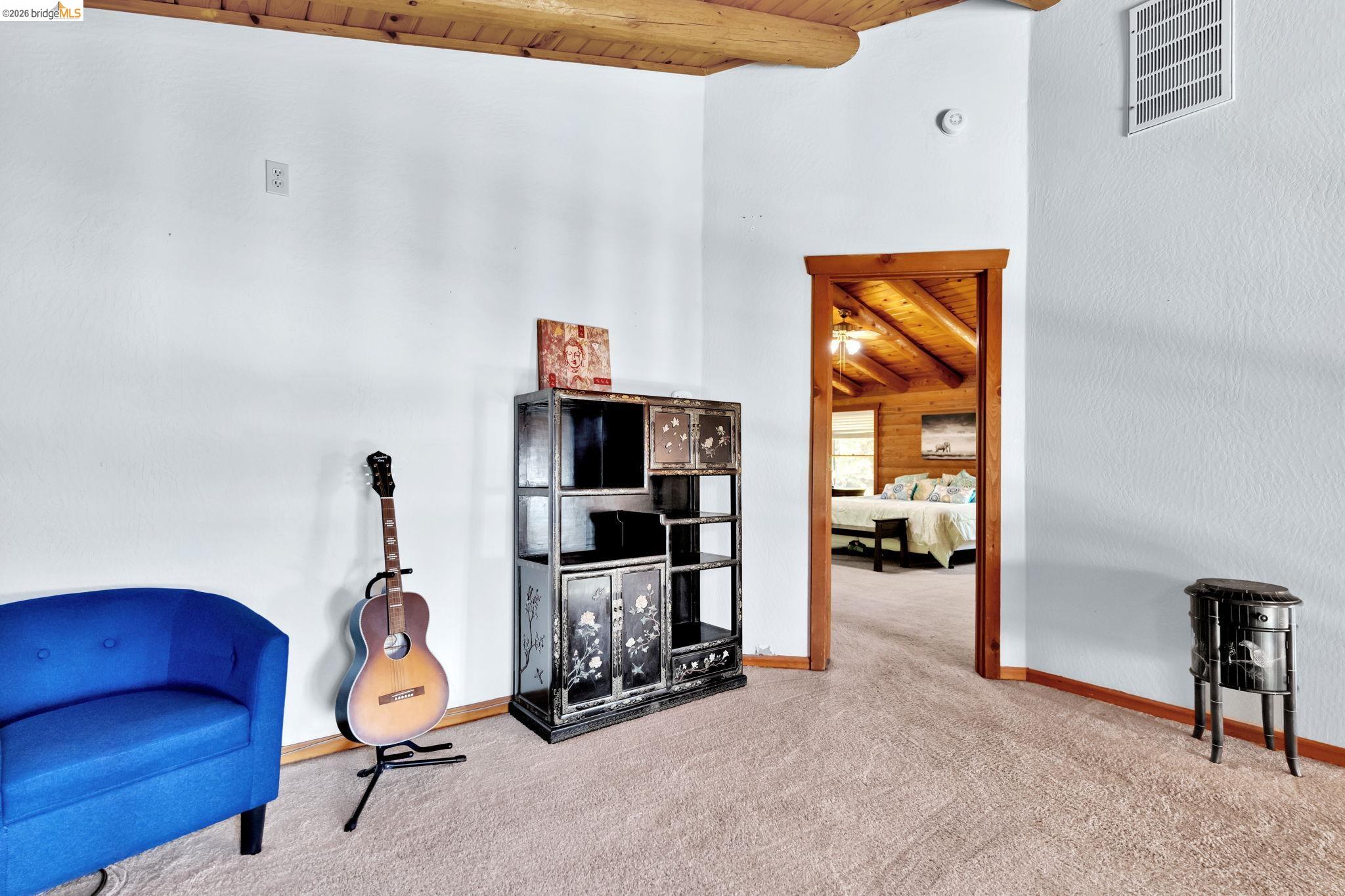 14799 Big Hill Road Sonora, CA 95370 - Photo 28 of 60 Living area featuring a wooden ceiling with exposed beams and light carpet