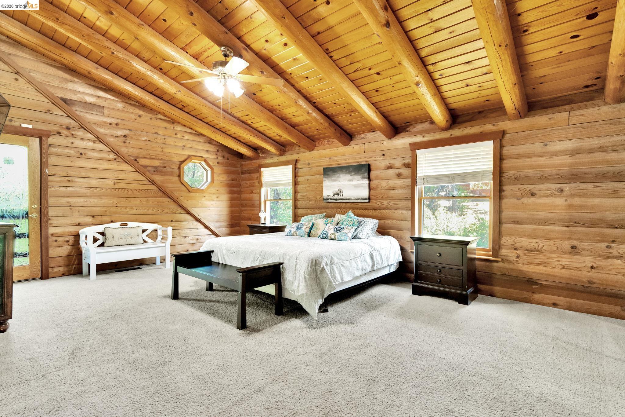 14799 Big Hill Road Sonora, CA 95370 - Photo 29 of 60 Bedroom featuring light colored carpet, wooden ceiling, multiple windows, wood walls, and ceiling fan