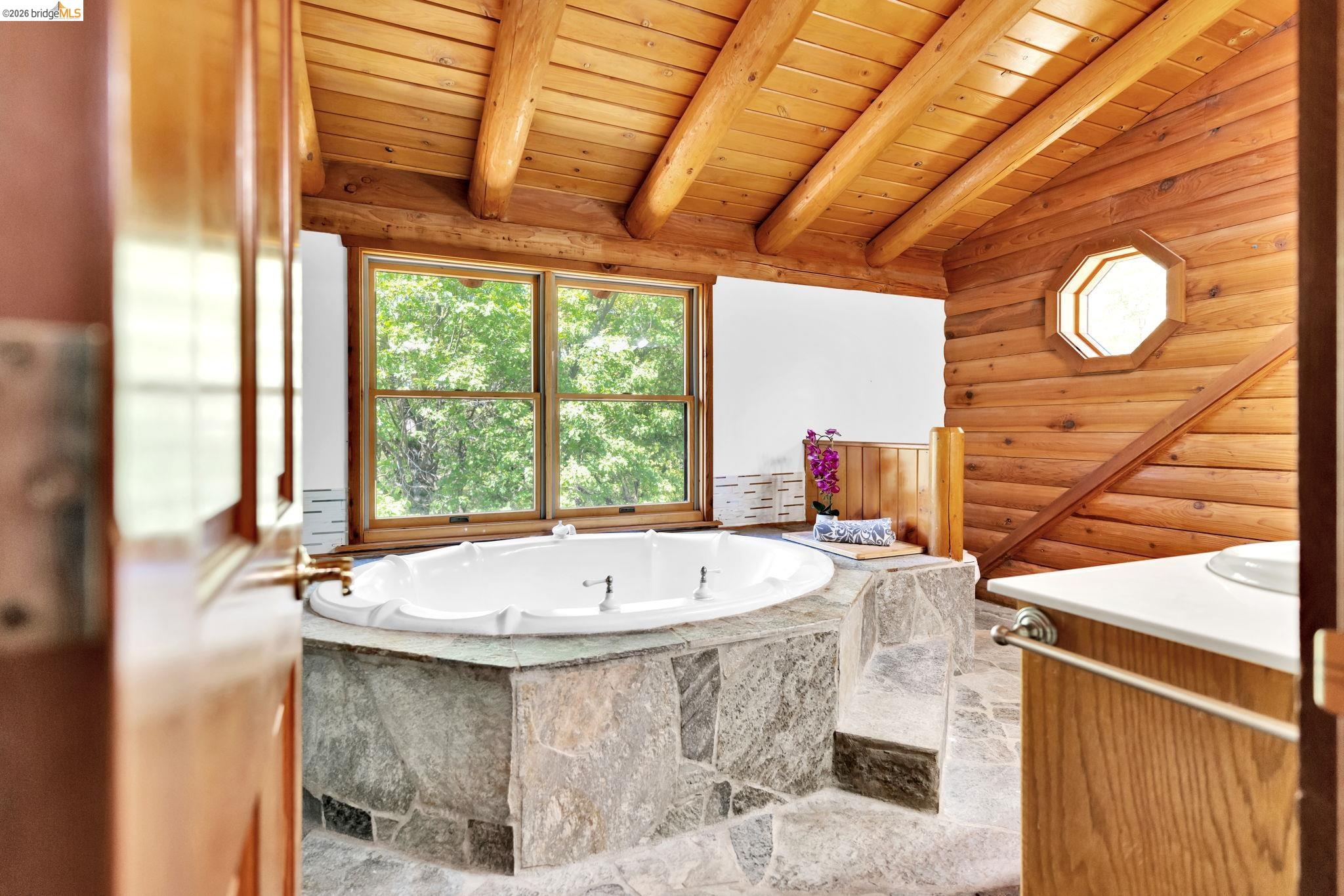 14799 Big Hill Road Sonora, CA 95370 - Photo 31 of 60 Bathroom with a bath, wooden ceiling, healthy amount of natural light, log walls, and vaulted ceiling with beams