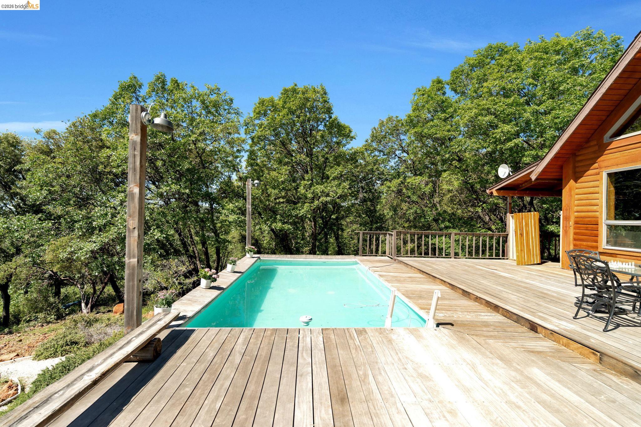 14799 Big Hill Road Sonora, CA 95370 - Photo 38 of 60 Swimming pool featuring a wooden deck and view of scattered trees