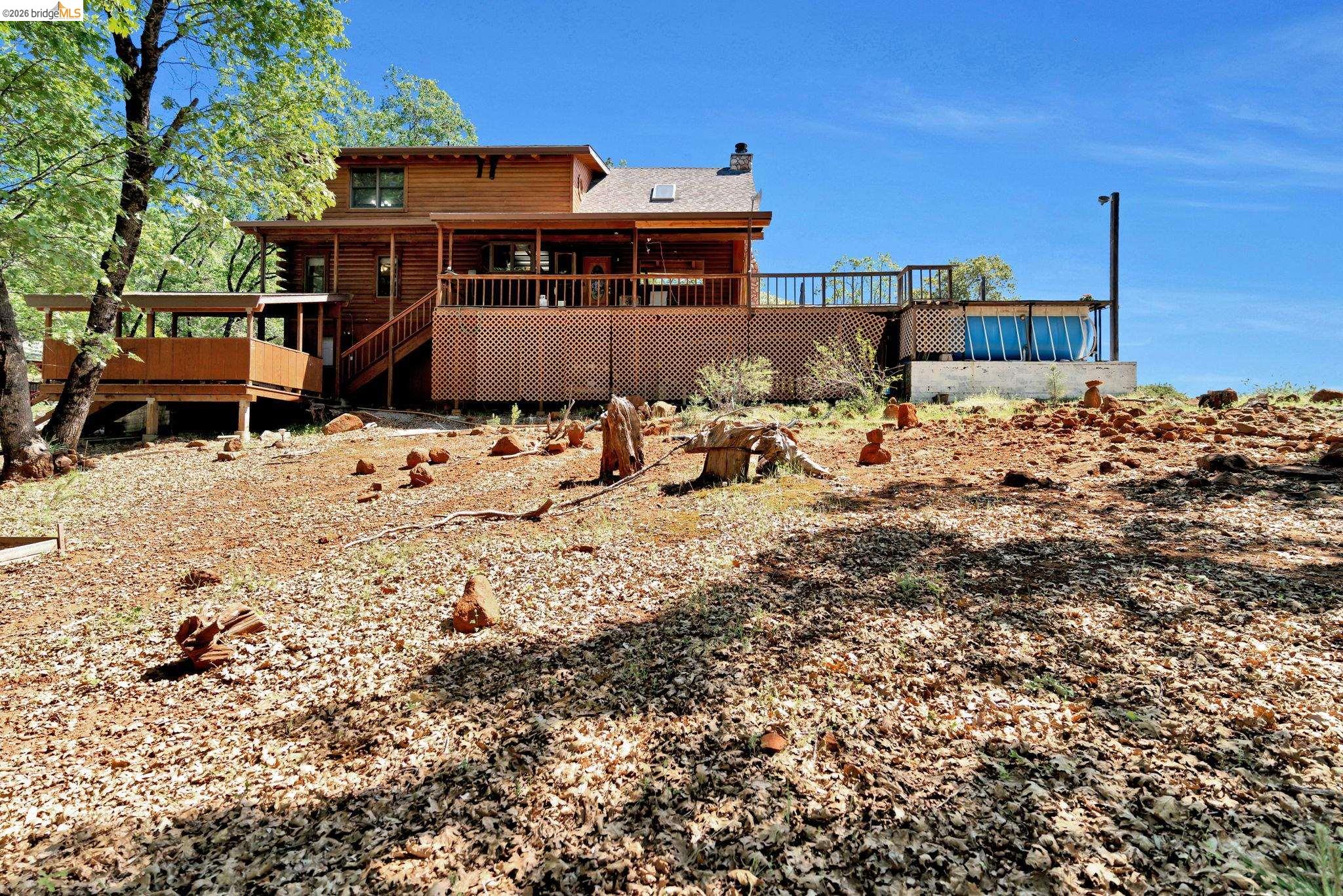 14799 Big Hill Road Sonora, CA 95370 - Photo 41 of 60 Back of house featuring a deck, a chimney, and log siding