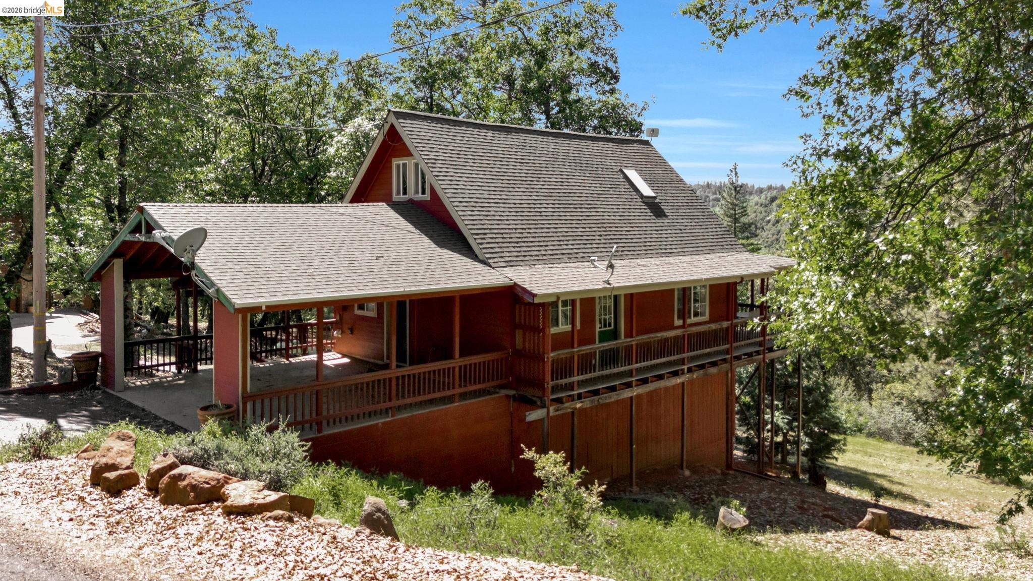 14799 Big Hill Road Sonora, CA 95370 - Photo 45 of 60 Rear view of house with roof with shingles, view of wooded area, and a porch