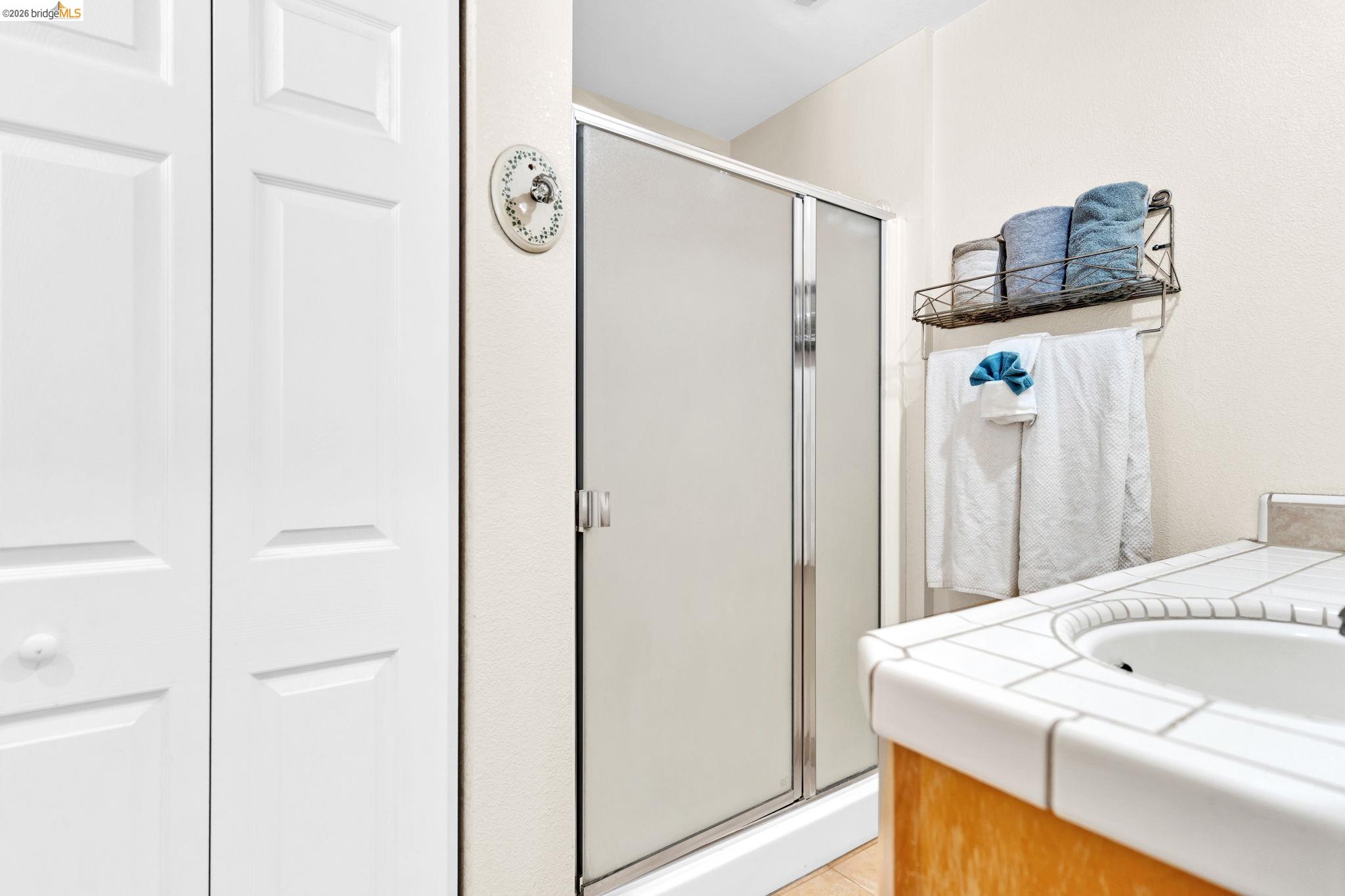 14799 Big Hill Road Sonora, CA 95370 - Photo 50 of 60 Full bath with vanity, a shower stall, a closet, and light tile patterned floors