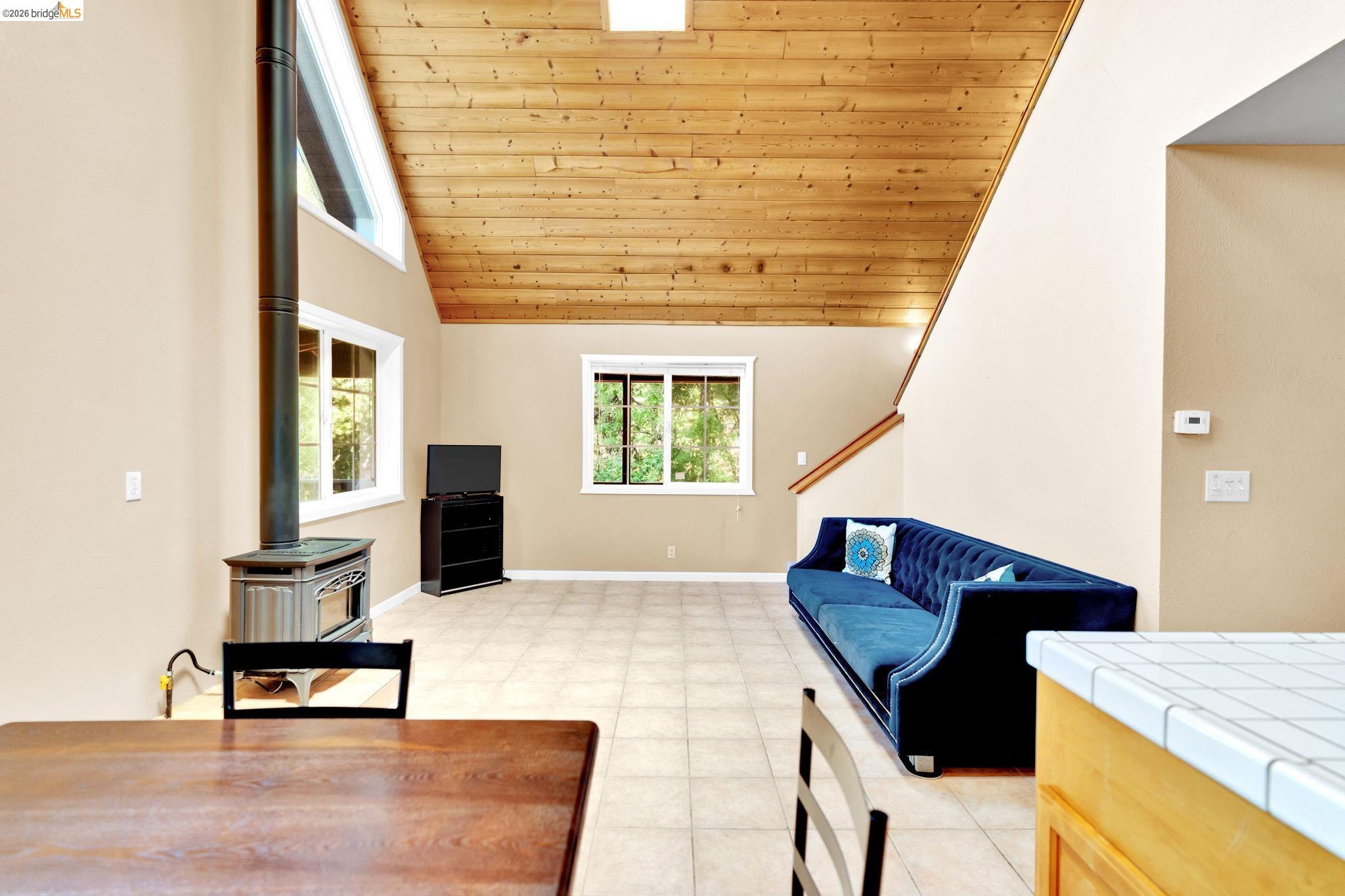 14799 Big Hill Road Sonora, CA 95370 - Photo 51 of 60 Living room featuring a vaulted wooden ceiling and a wood stove