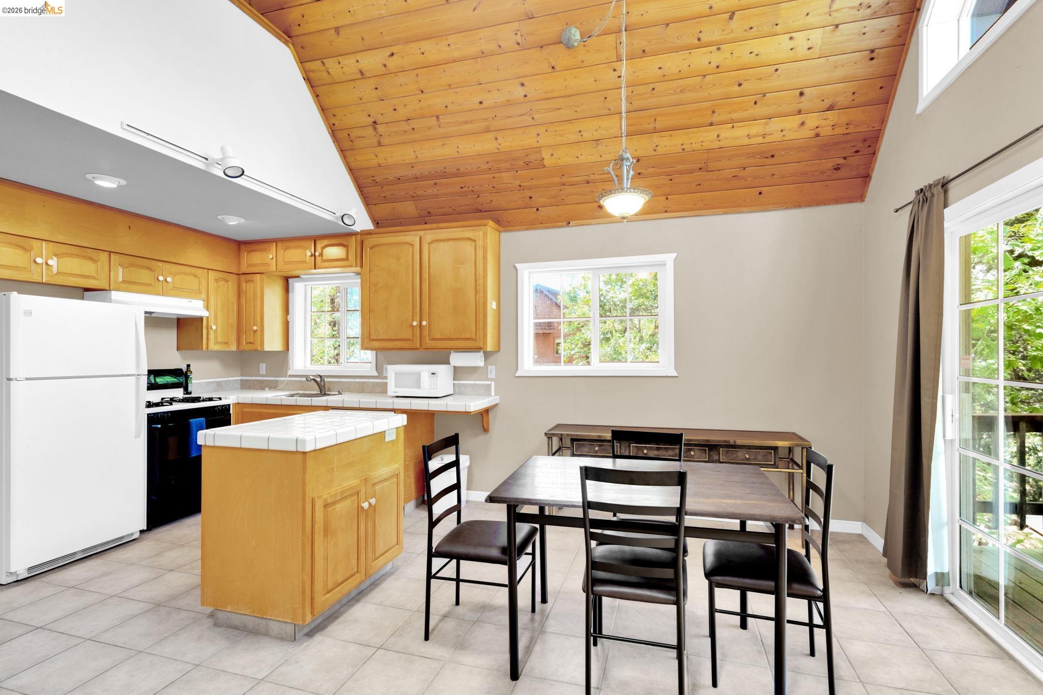 14799 Big Hill Road Sonora, CA 95370 - Photo 53 of 60 Kitchen with tile counters, white appliances, a vaulted wooden ceiling, decorative light fixtures, and light tile patterned flooring