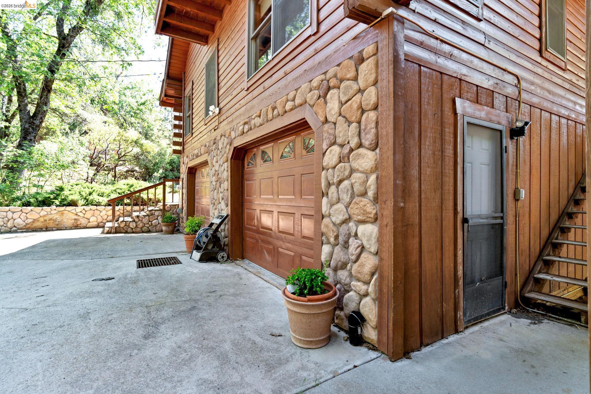 14799 Big Hill Road Sonora, CA 95370 - Photo 7 of 60 View of side of home with a garage, driveway, and stone siding