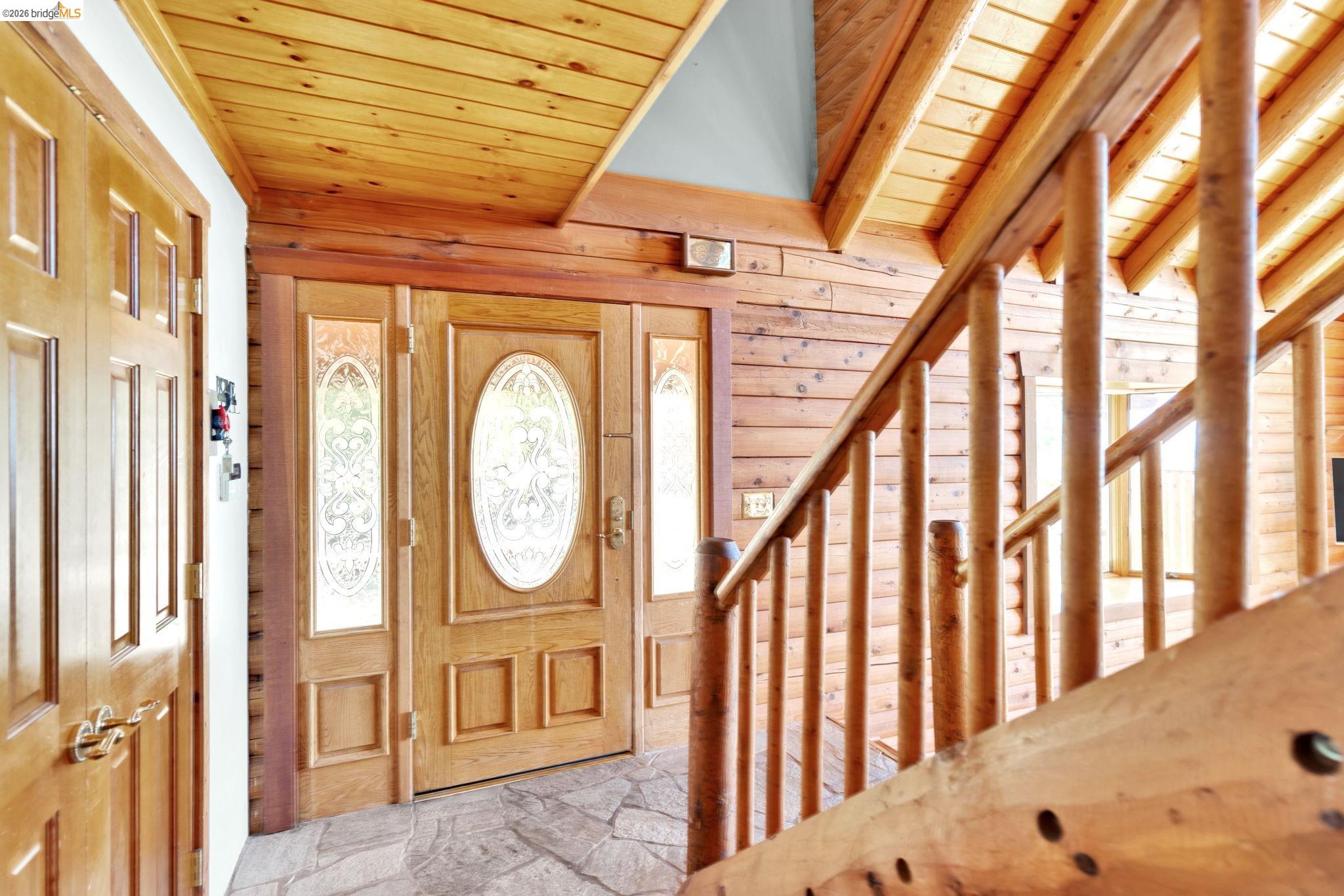 14799 Big Hill Road Sonora, CA 95370 - Photo 10 of 60 Foyer entrance featuring wooden ceiling, stone floors, and wooden walls