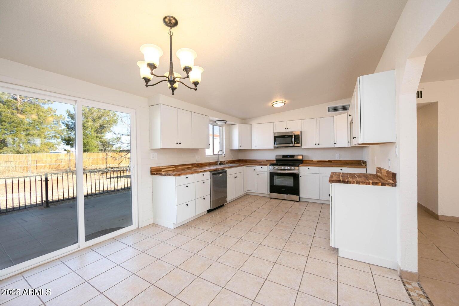 310 2nd Street Huachuca City, AZ 85616 - Photo 4 of 19 a kitchen with a stove a sink and white cabinets