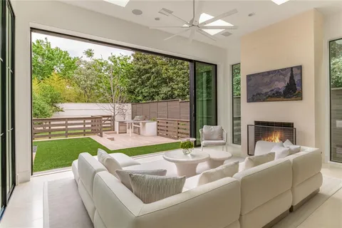 a living room with fireplace furniture and a large window