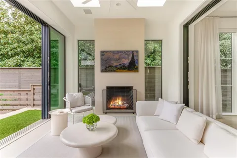 a living room with furniture a fireplace and a large window