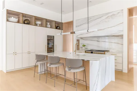 a kitchen with stainless steel appliances a white cabinets and chairs