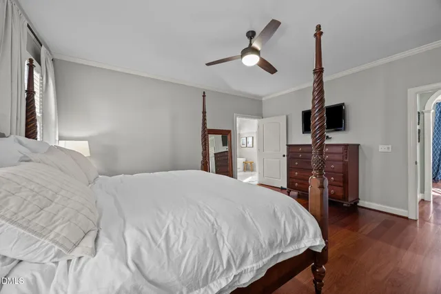 a bedroom with a bed a chandelier and pink walls