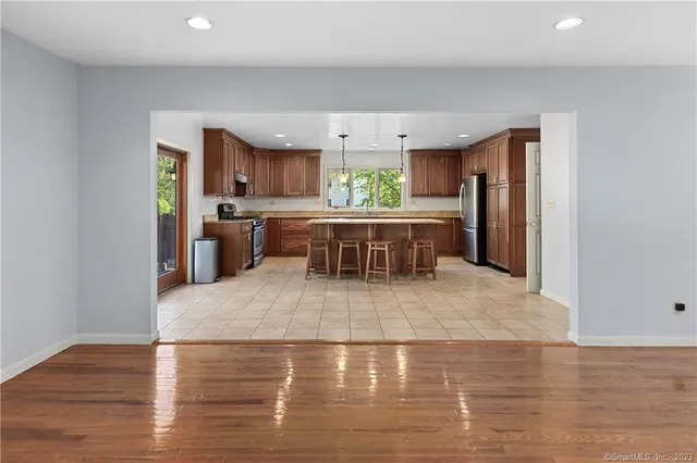 a large white kitchen with kitchen island a sink a stove and a refrigerator