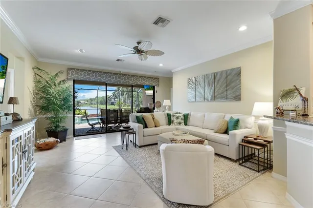a living room with furniture a large window and a chandelier