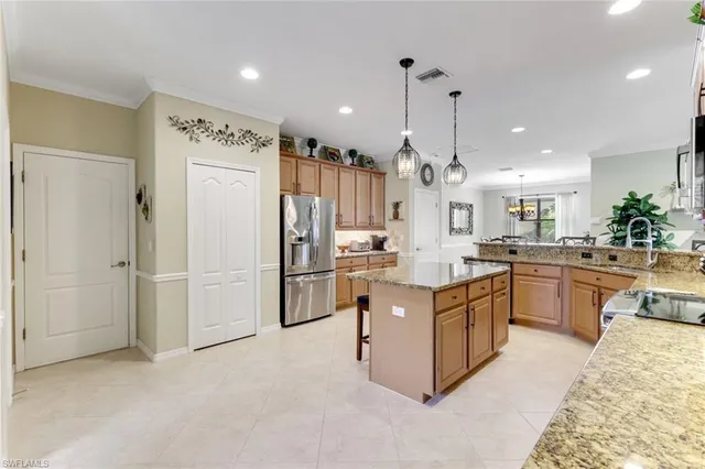 a open kitchen with stainless steel appliances granite countertop a refrigerator a oven and a sink