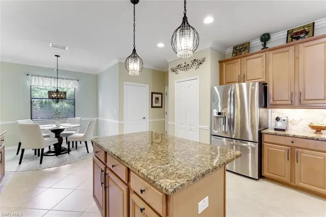 a kitchen with stainless steel appliances granite countertop a sink refrigerator and cabinets
