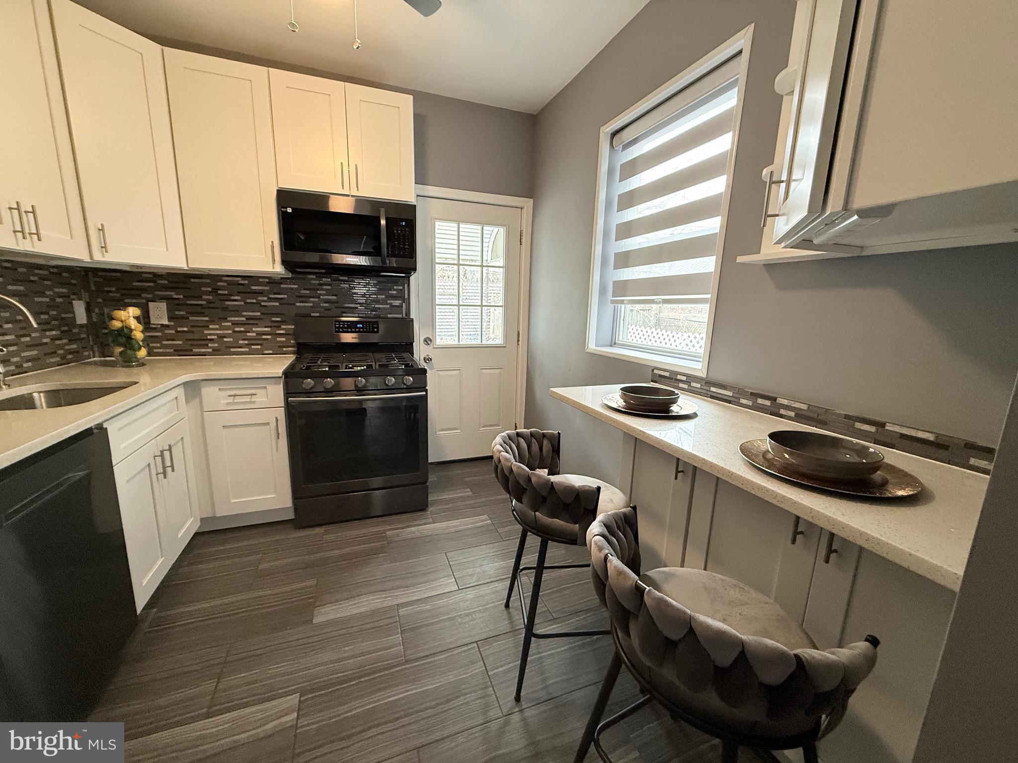 3146 Mercer Street Philadelphia, PA 19134 - Photo 22 of 22 a kitchen with a stove a sink and a microwave